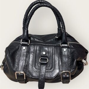 The Sak Black Leather Satchel with silver hardware and adjust straps